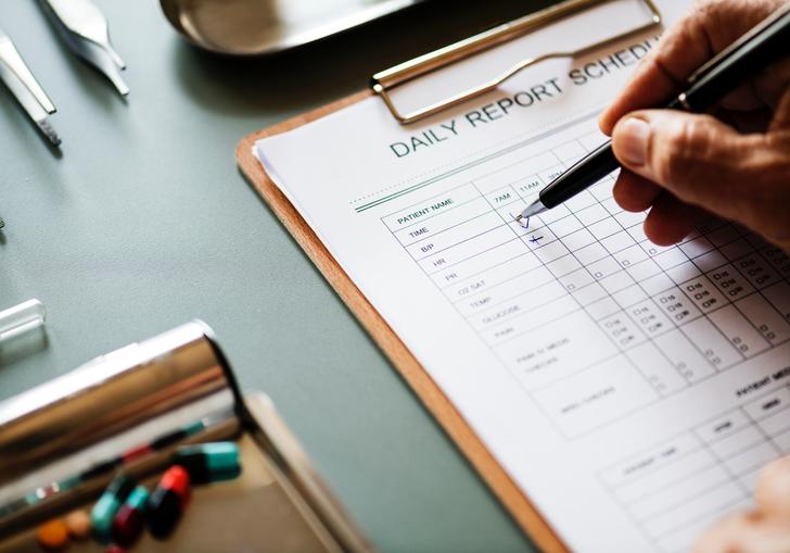 An image of a medical daily report on a clipboard and some other medical equipment