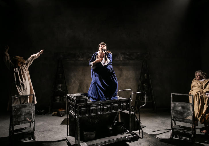 three women in ragged dresses dance and sing 