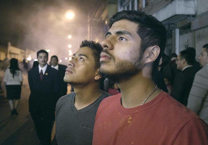 two men standing in a buy street looking upwards