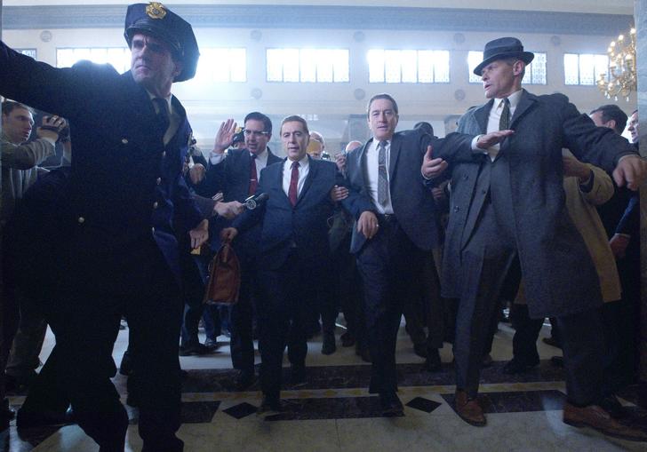 Al Pacino and Robert De Niro are escorted through a lobby by police in Martin Scorsese's The Irishman