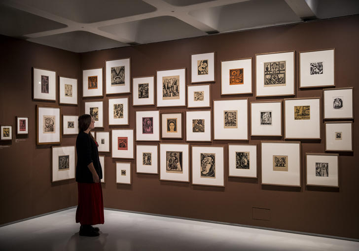 Woman looking at a series of small paintings