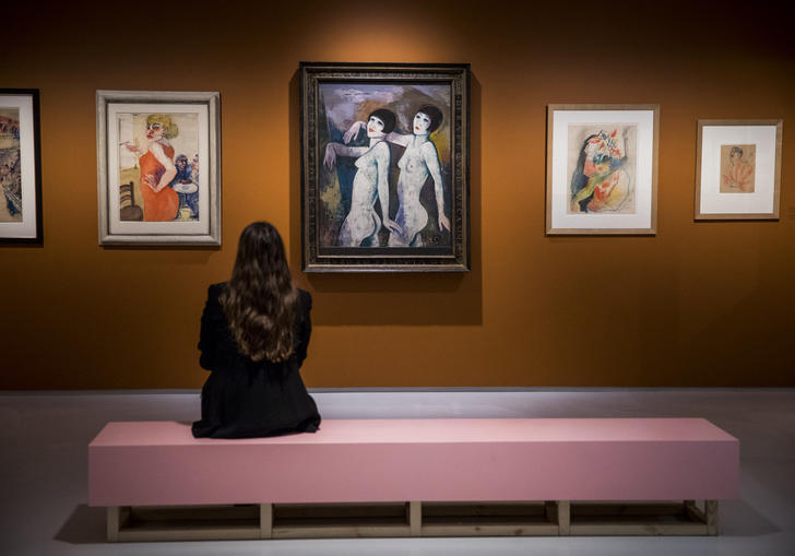 Woman looking at a painting of two figures