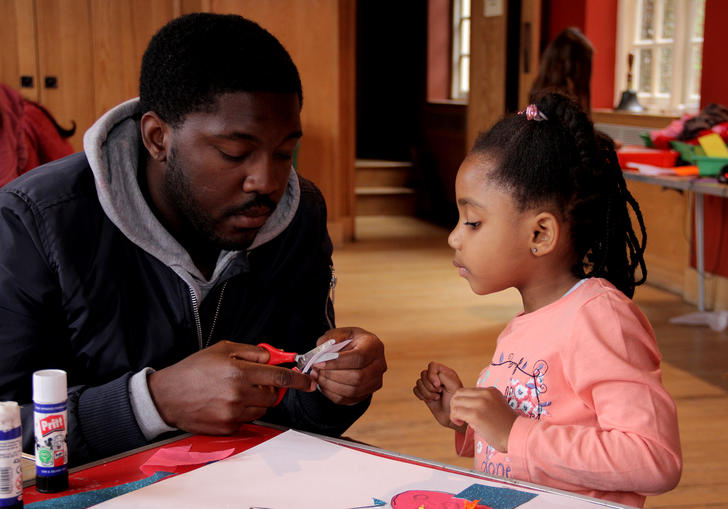 A father and daughter cut out shapes at the Imaginary Creatures Workshop