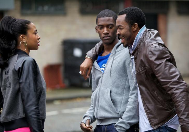 Two men and a woman chat on the street in Destiny Ekaragha's film Gone Too Far!