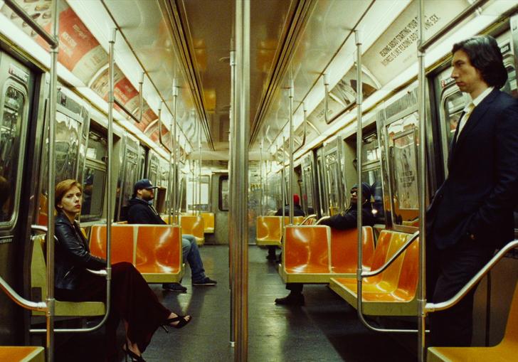 adam driver and scarlett johansson sit opposite each other on an empty subway train