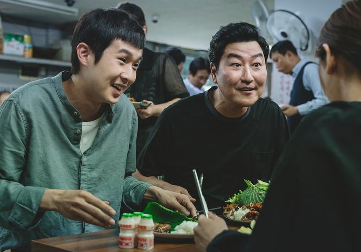 father and son smiling up at someone across the dinner table