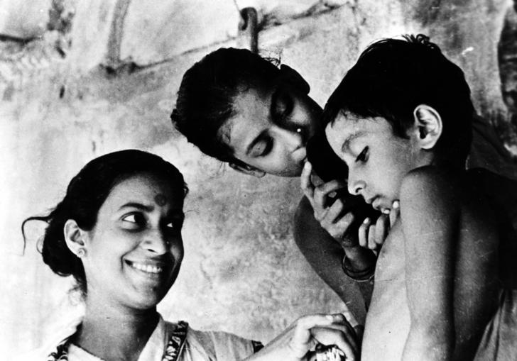 a mother smiling at her young son who is looking down