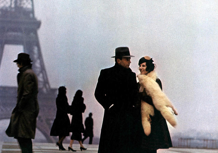 Jean-Louis Trintignant and Stefania Sandrelli stand bundled in winter coats on a grey day by the Eiffel Tower in Bertolucci's The Conformist
