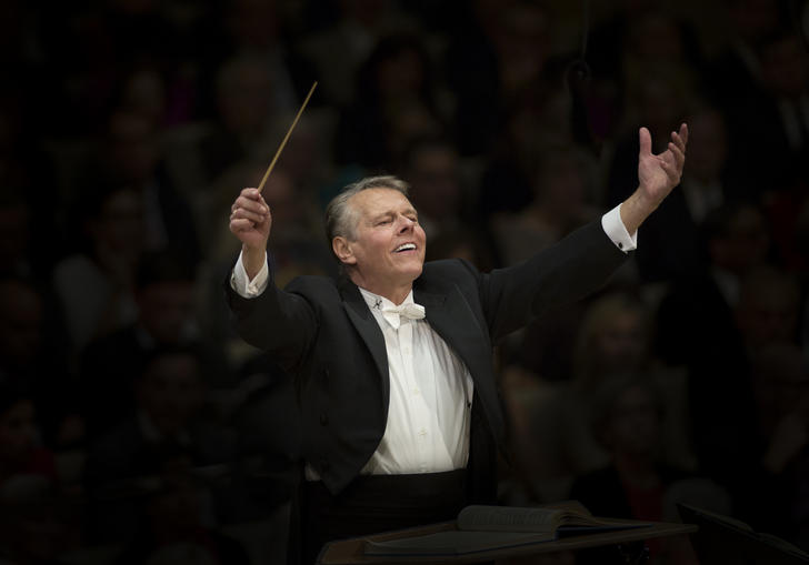 Mariss Jansons with raised arms conducting