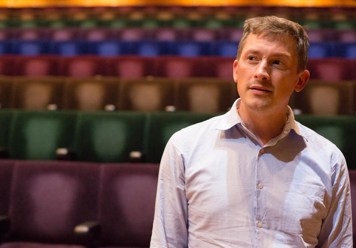 Man standing in front of hall seats