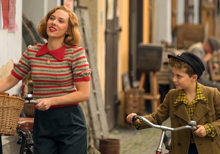 scarlett Johanssen and little Jojo walking down the street pushing bicycles