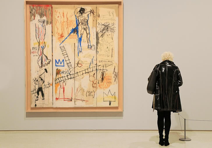 Woman looking at a Basquiat painting