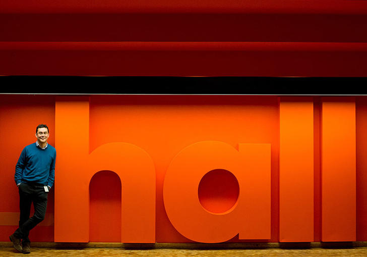 Man leaning on Hall sign