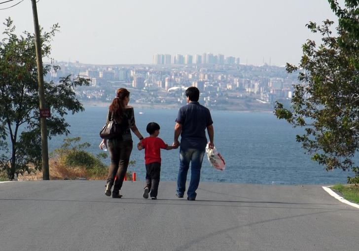 parents with their child between them holding both their hands 