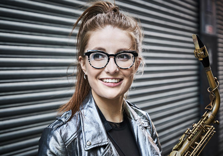 Jess Gillam smiling happily in anticipation of her concert at the lso