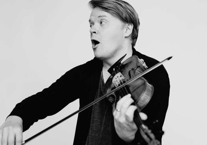 An image of Pekka joyfully playing his violin 