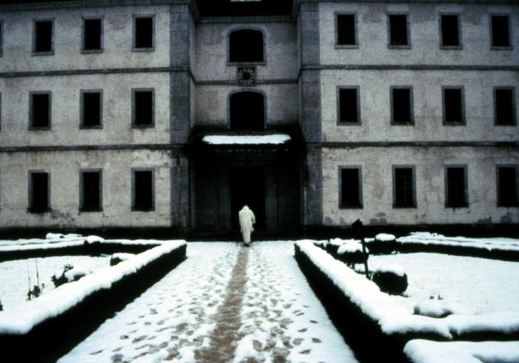 priest walking in the snow into a large building