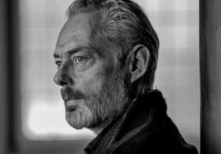 A black and white portrait of Mark Padmore gazing into the distance