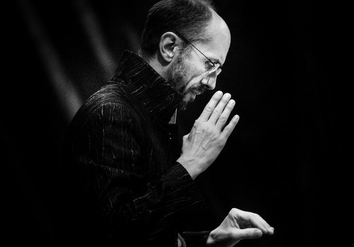A portrait of Herve conducting in a serious manner