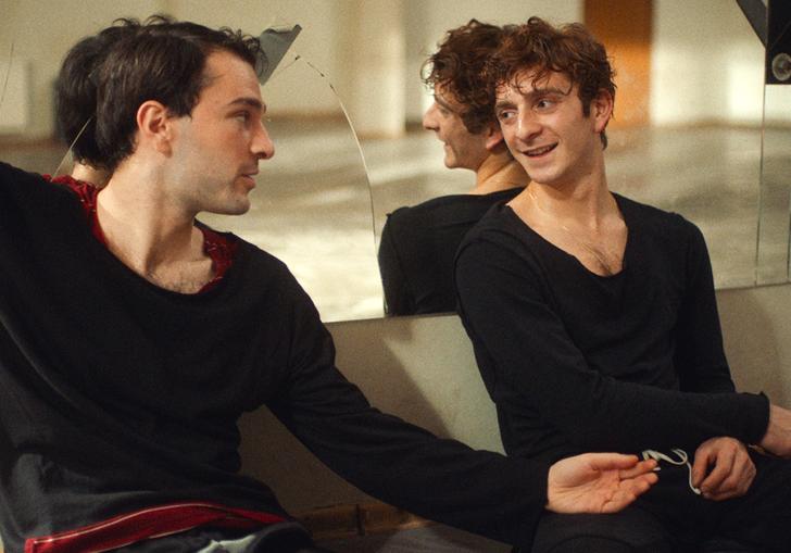 Two young male dancers look at each in a dance studio