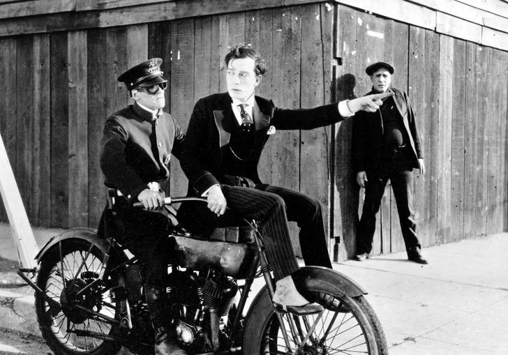 buster keaton sitting on the front of a motorbike