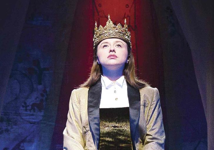 a woman sitting on a throne with a crown on her head