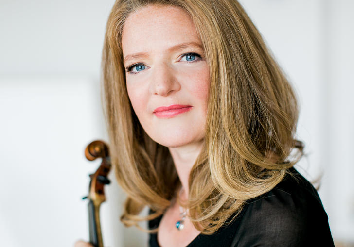 A portrait Rachel Podger, violin in hand, her blue eyes glistening