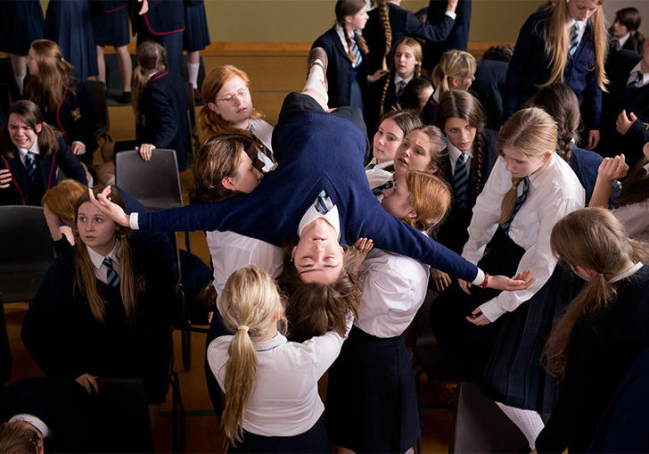 actor maisie williams being carried by many schoolgirls