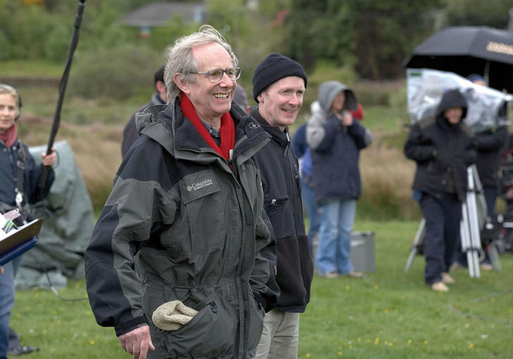 ken loach smiling in a field with other actors and film crew