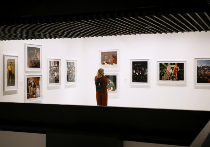 Woman looking at a wall filled with photographs