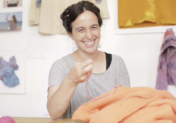 Woman with needle fixing salmon pink jumper