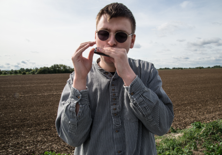 a young man with sunglasses and a harmonica