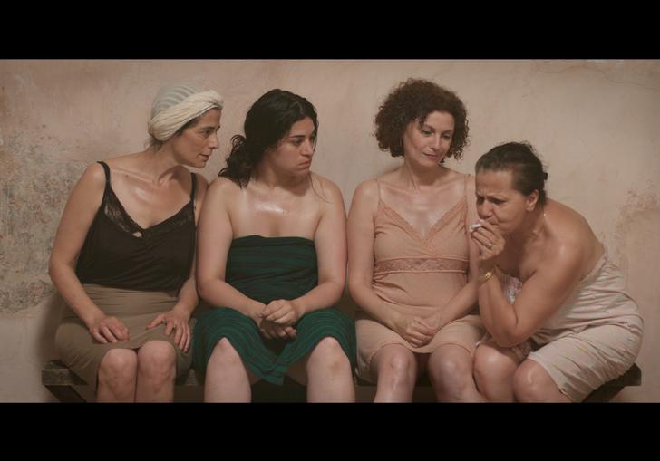 a group of women are in a bathing house together, talking