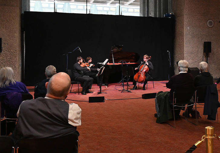 Audiences enjoying a socially distanced performance by the Mithras Trio on Barbican Level G