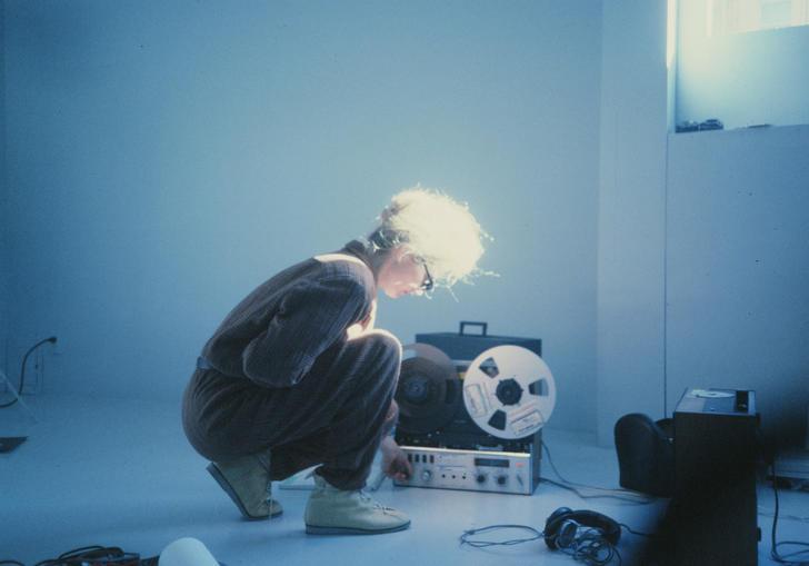 A woman kneels down in front of a recorder