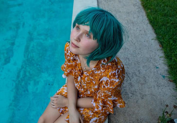 Eliza Scanlen looks up at the sky in a blue wig