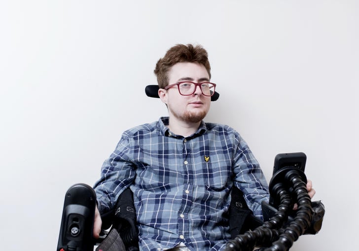 photo of a man with glasses in a wheelchair