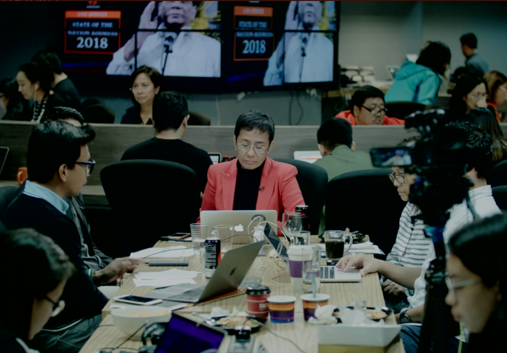 a group of people sit around a conference table