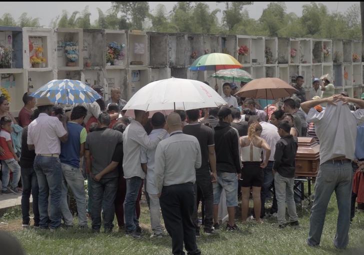 a group of people stand together with umbrellas