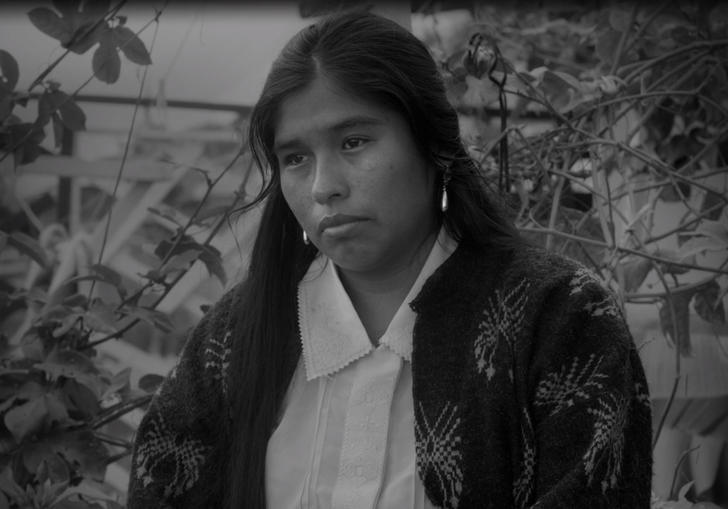 a woman looks forlorn sitting in a garden