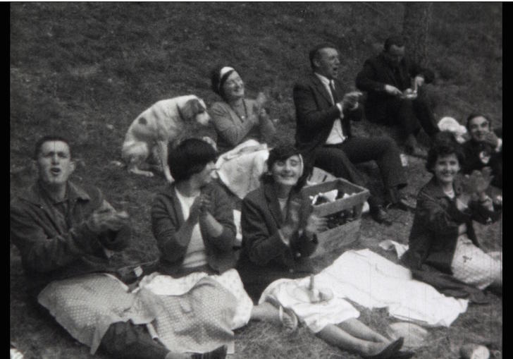 a black and white image of a group of people having a picnic