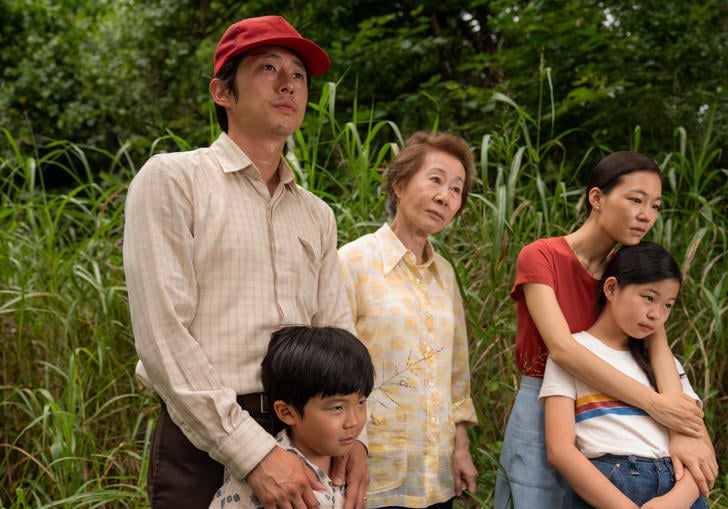 a family stand together with green landscape behind them