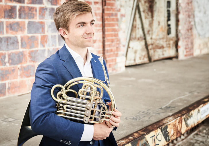 Ben Goldscheider looking into the distance with his French Horn