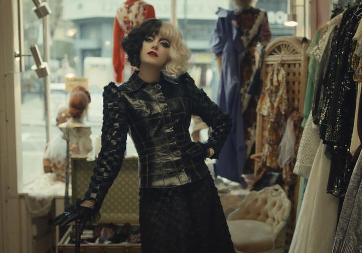 cruella stands in a clothes shop
