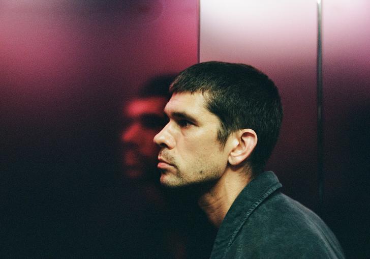 Ben Whishaw with his face pressed against a pink metallic wall