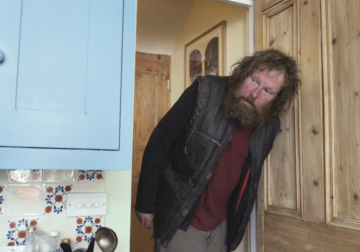 a homeless man pops his head through a kitchen door