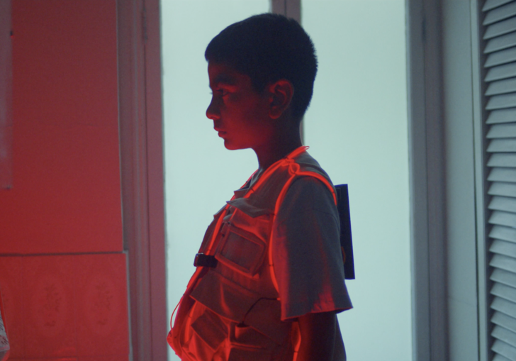 a young boy's profile covered in red light
