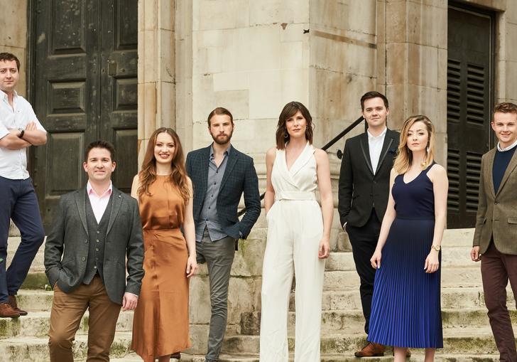 The members of Voces 8, standing on some steps