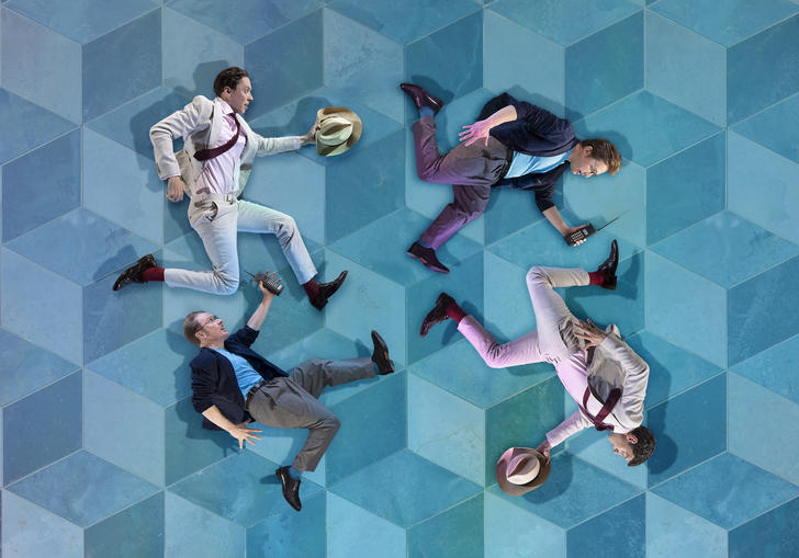 Four cutout images of running men in suits are placed on a blue Escher style tiled background. 