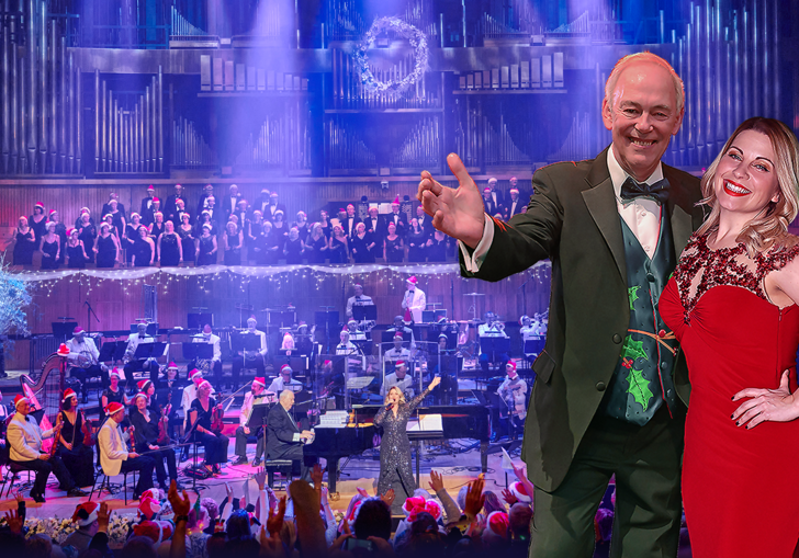 Jonathan Cohen and Louise Dearman smiling in front of an orchestra and choir